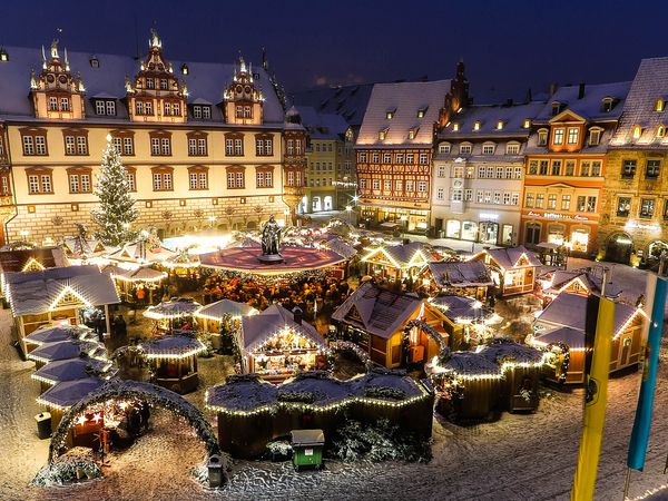 Eine prächtige Kulisse: hübsch geschmückte Holzbuden auf dem Coburger Weihnachtsmarkt im Herzen der malerischen Altstadt