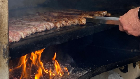 Coburger Bratwürste liegen auf dem Grill bei offenem Feuer 