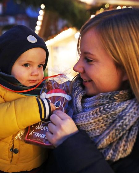 Mutter hat ihr Kind auf dem Coburger Weihnachtsmarkt auf dem Arm.